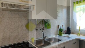 Eine moderne Küche mit Gasherd, doppeltem Spülbecken und gefliestem Fliesenspiegel.