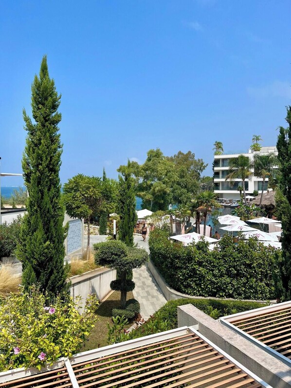 Un complexe hôtelier doté d’une piscine, de palmiers et surplombant un ciel bleu azur.