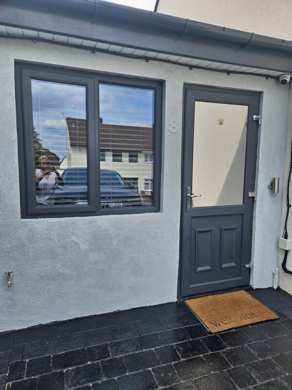Enter through the door with a modern handle and peephole, into a welcoming space.