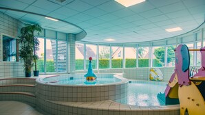 Ein Poolbereich mit kreisförmigem Design, einem großen Fenster und einer Topfpflanze.