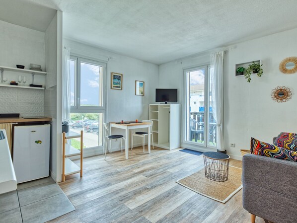 Ett modernt och väl upplyst rum med kök, matplats och sittgrupp.