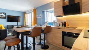 A modern kitchen with wooden cabinets, a built-in oven, and a flat-screen TV. - Port Arcachon by Interhome (Arcachon)