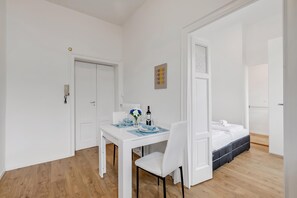 A hotel room with a dining area, a bed, and a bathroom.