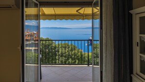 Un balcon avec vue sur la mer et les montagnes.