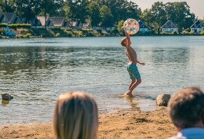 Uma pessoa brincando com um frisbee em um lago.