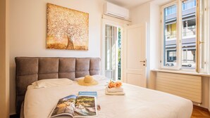 Un lit bien fait, avec un magazine, un chapeau et un bouquet de fleurs.