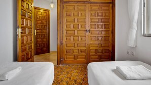 A hotel room with two beds, a large wooden wardrobe, and a tiled floor. - El Rocio 7E1 - Terrace, Swimming Pool, Sea Views (Torremolinos)