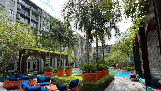 A courtyard with outdoor seating, a swimming pool, and a building with multiple floors. - RoomQuest Hua Hin Lahabana (Hua Hin)