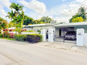 A gated residential property with a white exterior, a garage, and a driveway. - Beachcomber 3 Bedroom Home by Bluescape (Holetown)