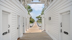 A wooden pathway leading to a row of white buildings with doors labeled "Ocean Park" and "Gentlemen." - Screened Porches, Decks, Rockers, Hammocks And An Upstairs Balcony With Ocean Views 5 Bedroom Home by Peace Vacations (Georgetown)