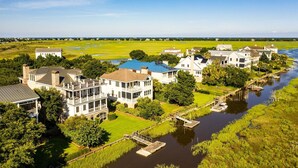 A riverside property with multiple houses, a dock, and a bridge. - Delightful, Low Country Home With Dock On Debordieu Channel 4 Bedroom Home by Peace Vacations (Georgetown)