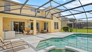 Et moderne poolområde udendørs med en glasinddækket terrasse, liggestole og krystalklar himmel.