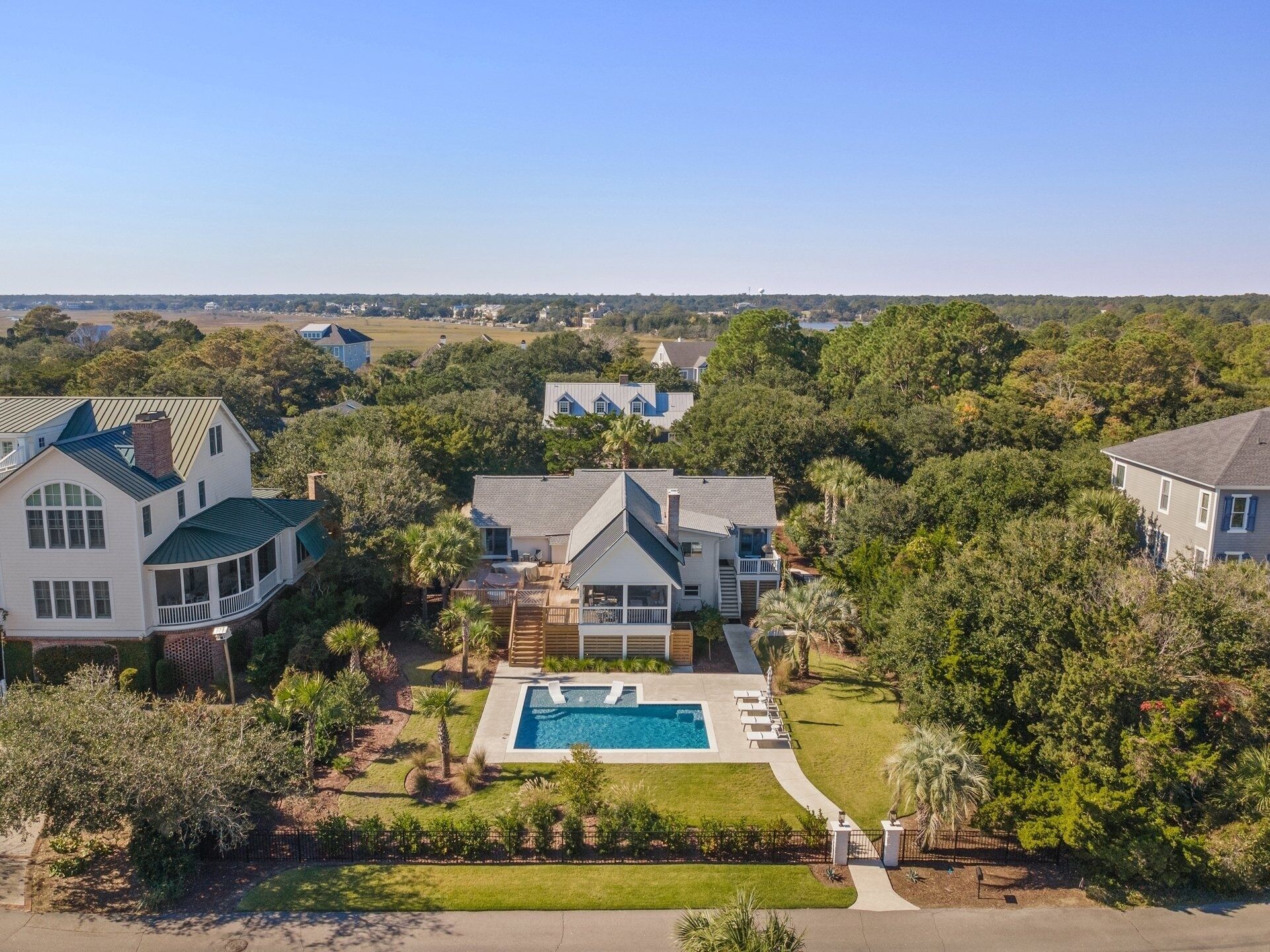 A residential area with multiple houses, a swimming pool, and a well-maintained lawn.