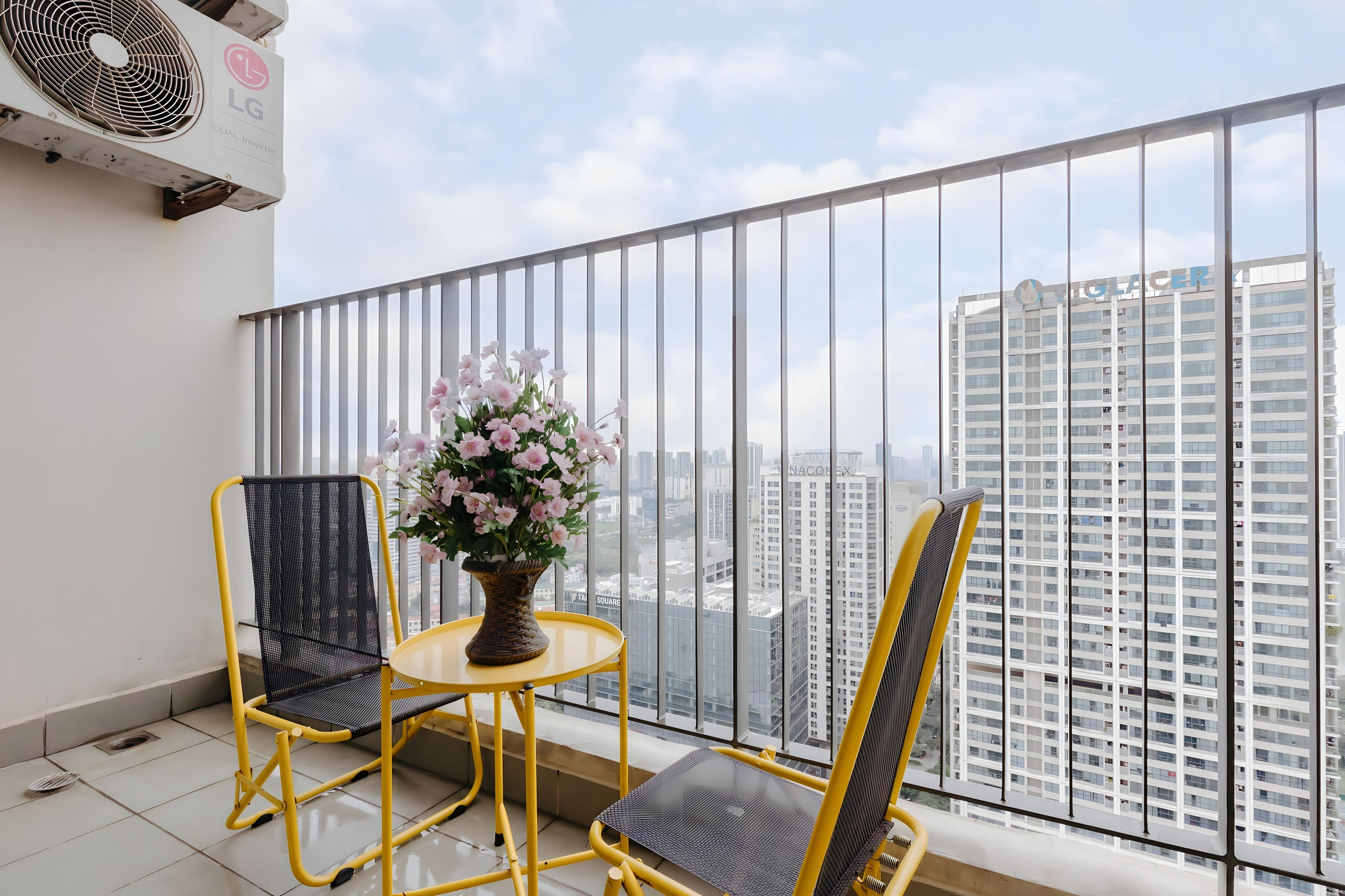 A balcony with two chairs, a small table, and a potted plant.