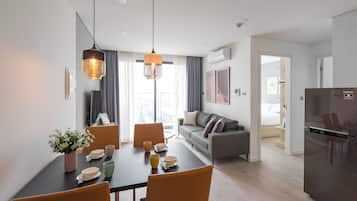 A modern apartment with a dining area, kitchen, and living space.
