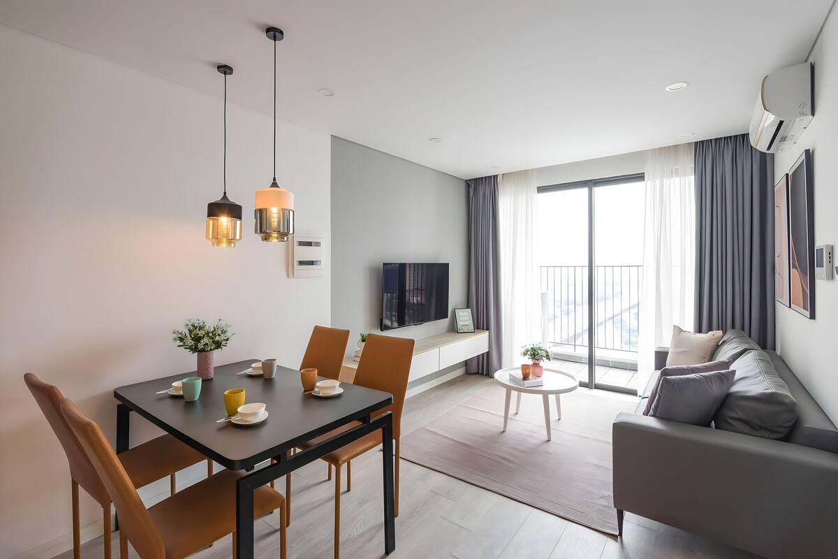 Una sala moderna con comedor, un sofá y un televisor.