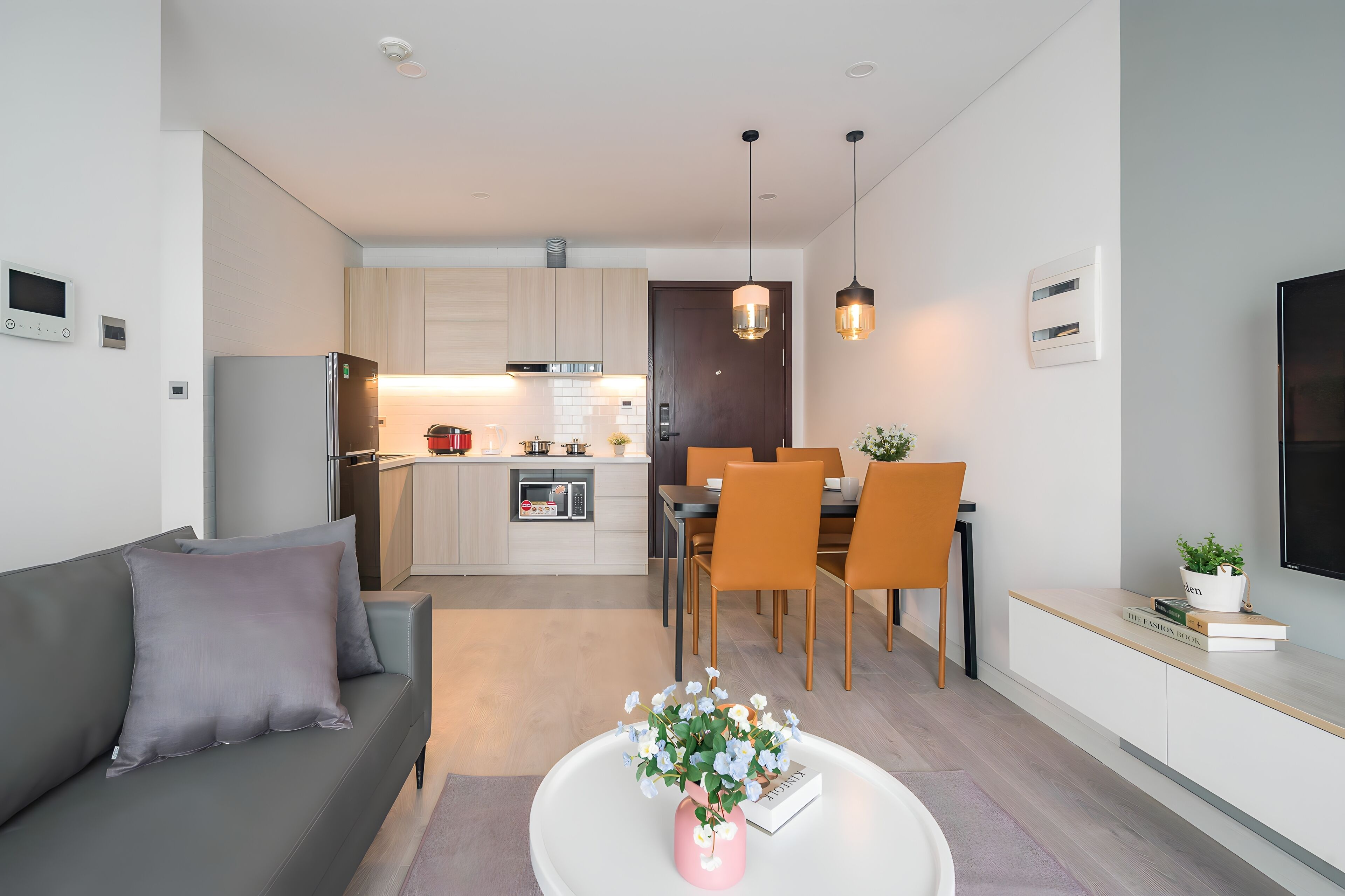 A modern apartment with a living room, dining area, and kitchen.