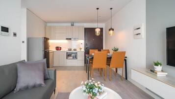 A modern apartment with a living room, dining area, and kitchen.