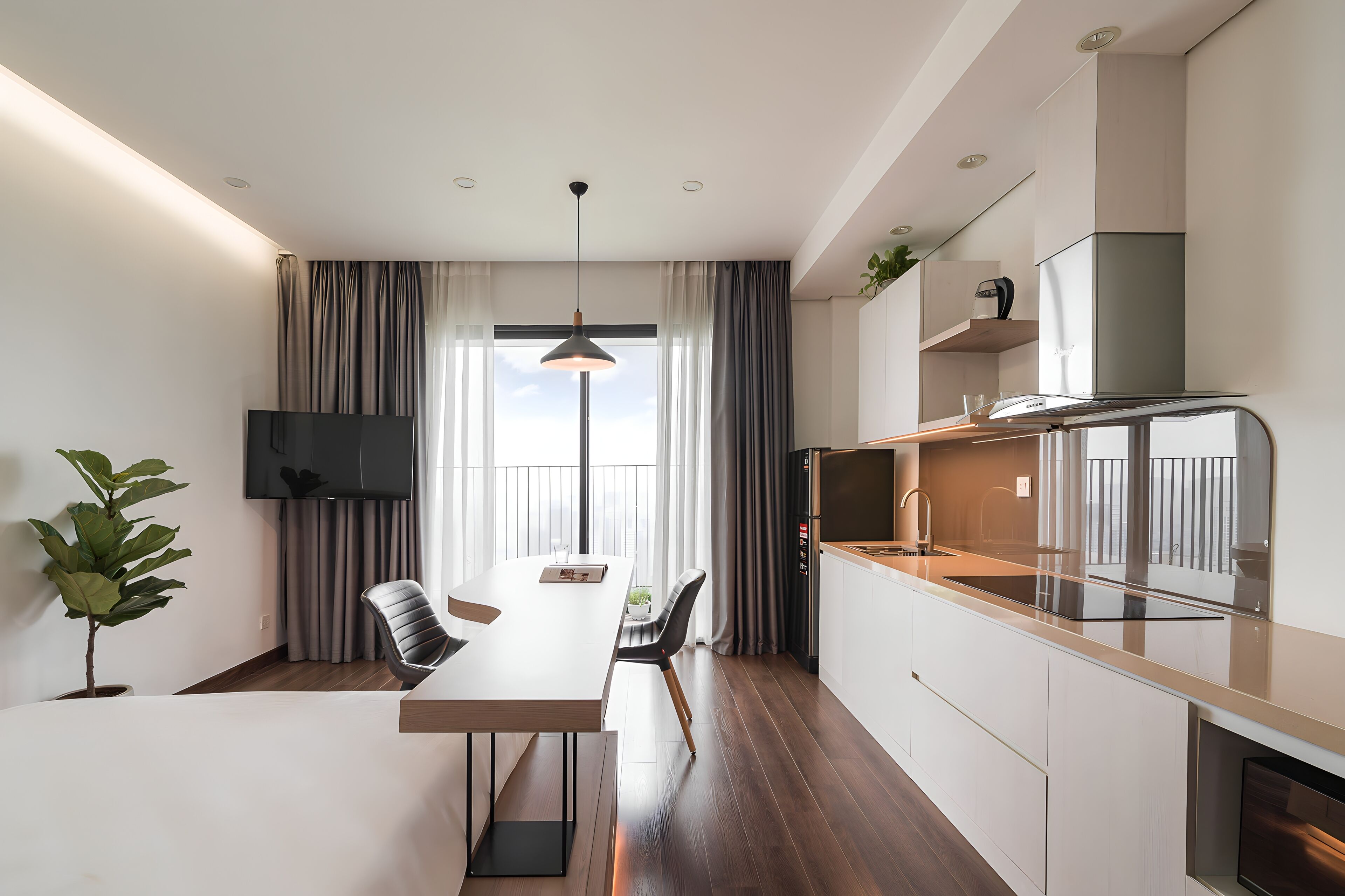 A modern kitchen with a built-in oven, a dining area with a white table and chairs, and a large window with curtains.