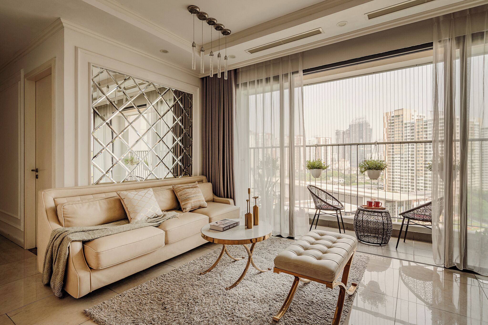 A modern living room with a beige sofa, a round coffee table, and a view of a cityscape through large windows.