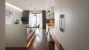 Une cuisine moderne avec un coin repas, un plancher en bois et une vue sur l’extérieur.