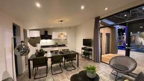 Un espace de vie moderne comprenant un coin repas, une cuisine et un coin salon.