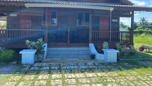A wooden house with a porch, two windows, and a door. - Hotel O Sri Ayu Inn (Gurun)