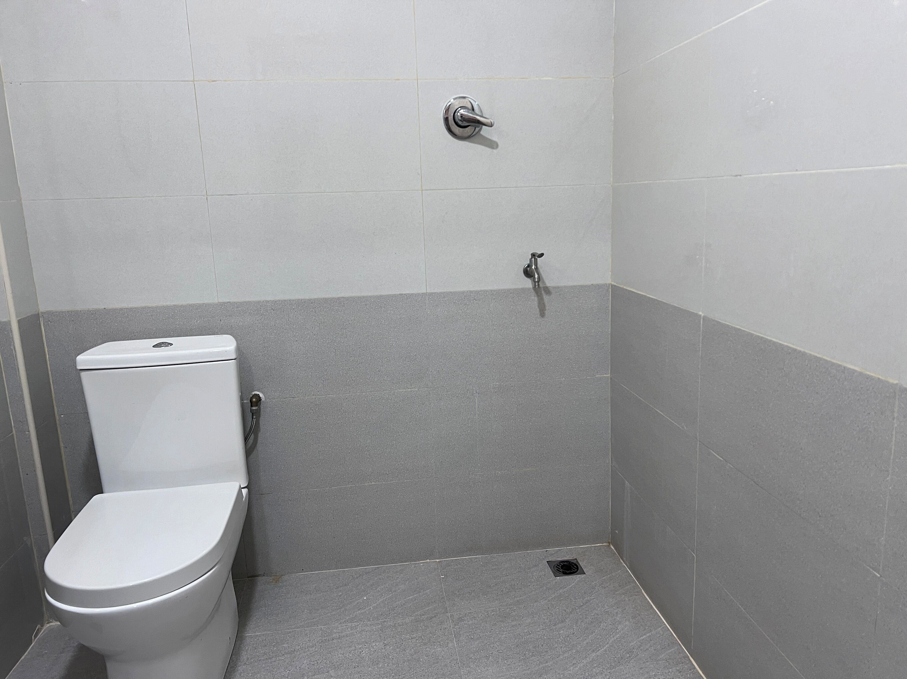 A small, enclosed bathroom with a toilet, a shower, and a sink.