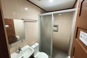 A bathroom with a glass shower enclosure, a sink, and a toilet. -  Sea Jewel Hotel Puerto Galera powered by Cocotel (Puerto Galera)