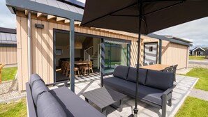 Un espace extérieur aménagé avec un canapé, une table et un parasol.