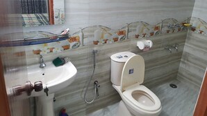 Une salle de bain équipée de toilettes, d’un lavabo et d’une douche.