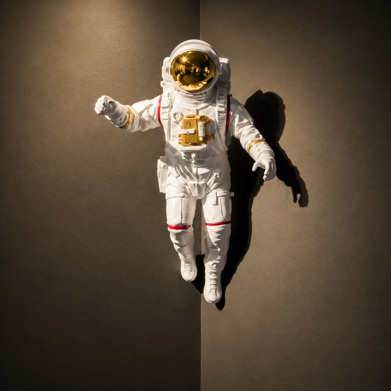 Eine Mannequin in einem weißen Raumanzug mit roten Akzenten, vor einer schlichten Wand platziert.