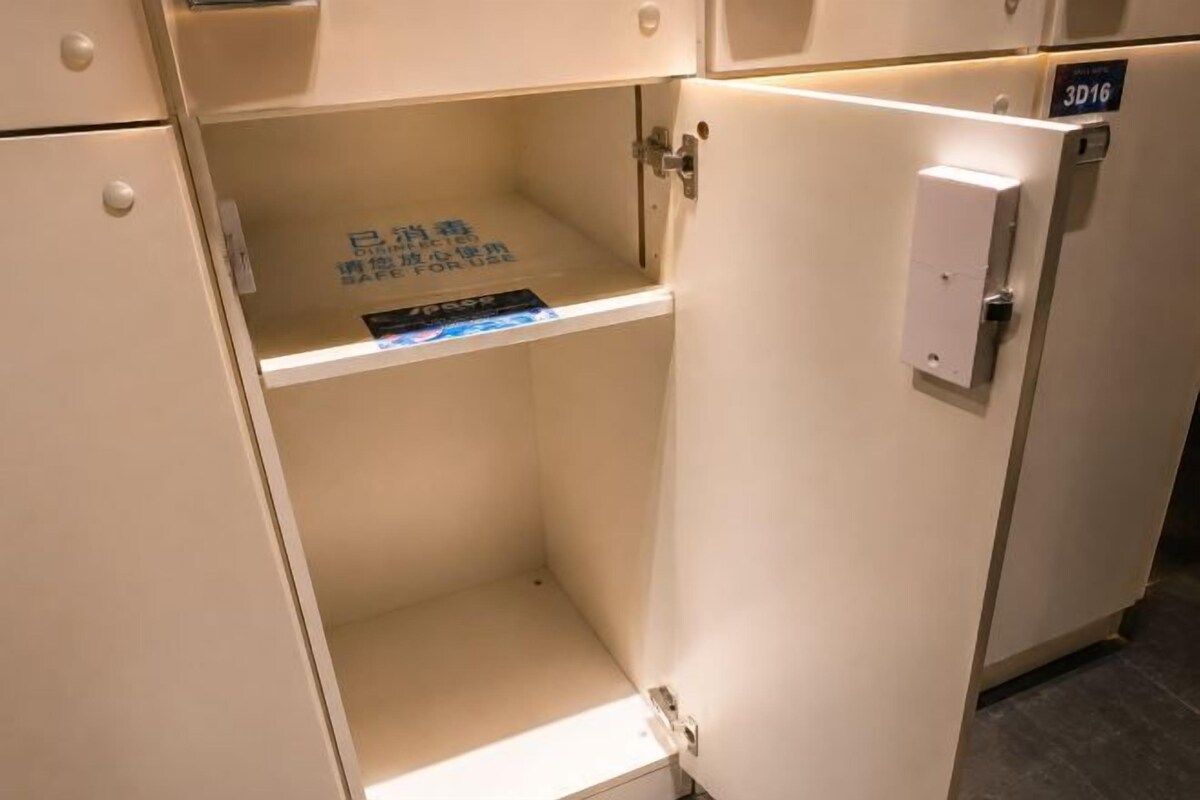 A white cabinet with a small shelf, a door with a handle, and a sign with text.