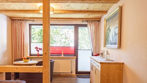 A wooden interior with a dining table, a radiator, and a window with curtains. - Apartment 'Fewo Wendelstein' with Shared Terrace, Shared Garden and Wi-Fi (Willingen (Upland))