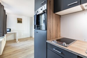 A modern kitchen with a built-in oven, a microwave, and a wooden countertop.