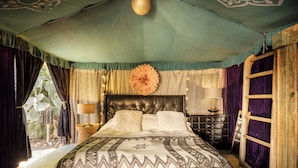 A spacious bedroom with a large bed, a wooden headboard, and a view of the outdoors. - Sultan's Tent at Caesarea by Sea N' Rent (Hof HaCarmel)