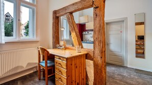A room with a wooden desk, a chair, a radiator, a window, and a door. - Studio Apartment 'Ferienwohnung Stralsund' with Wi-Fi (Stralsund)