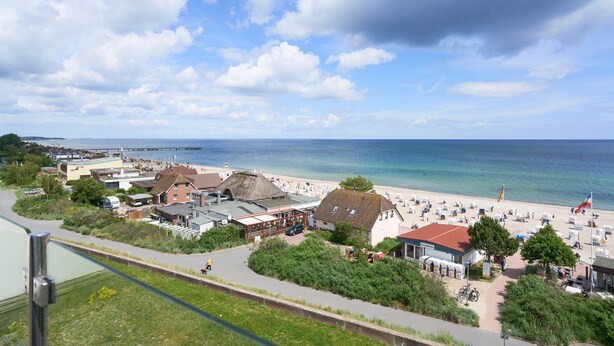 Une ville côtière avec une plage, des bâtiments et une jetée.