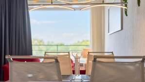 Un espace repas comprenant une table, des chaises et un luminaire suspendu.