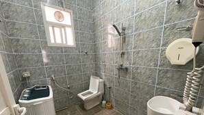 Une salle de bain équipée de toilettes, d’un bidet et d’un sèche-mains.