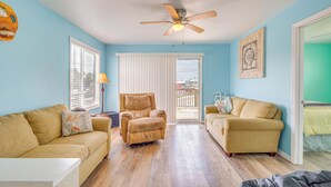 A living room with two beige sofas, a tan armchair, a ceiling fan, and a view through a sliding glass door to the outside. - Gulf of Mexico Beach Cottage: Walk to Boat Ramp! (Horseshoe Beach)