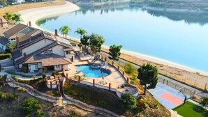 A residential property with a swimming pool, a basketball court, and a beach view. - Stunning Panoramic Waterfront Pool Home Escape (Anaheim)