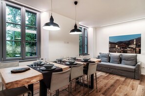Un comedor con mesa de madera, sillas y lámparas colgantes.