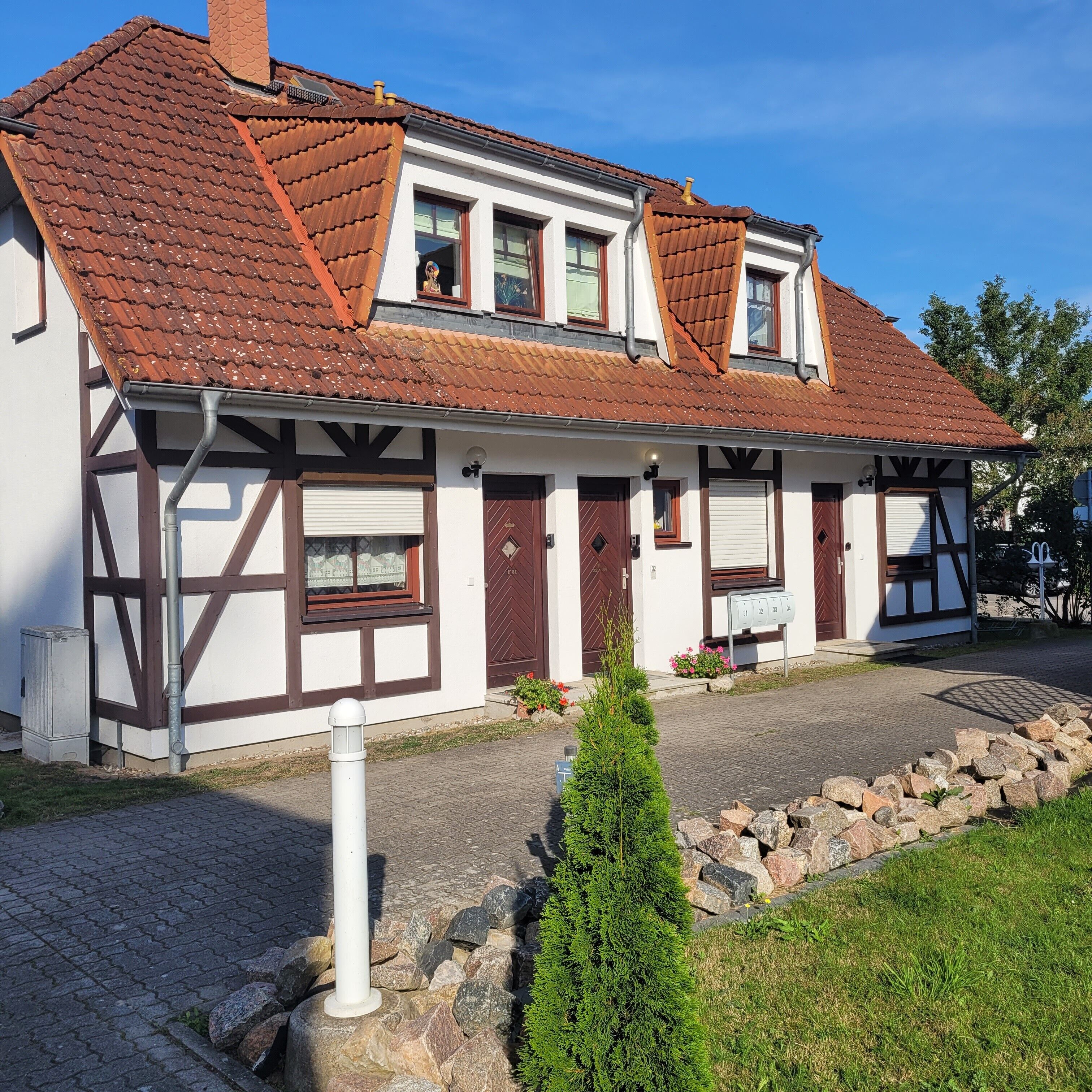 A traditional half-timbered house with a sloped roof, a front door, and a mailbox.