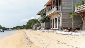 Une propriété située en bord de mer, avec un bâtiment en bois doté de balcons et d’une véranda couverte.
