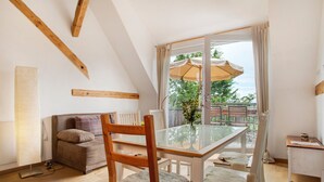 Una habitación acogedora con una mesa de vidrio, vigas de madera en el techo, un sofá y vistas al exterior.