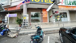 Ett hotell med en tydlig skylt som visar ordet ”HOTEL”, en parkeringsplats och ett café i närheten.
