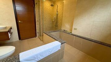 A bathroom with a shower, toilet, and vanity.