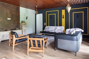 Un salon moderne comprenant un canapé, des fauteuils, une table basse et un meuble décoratif.