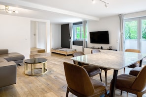Un salon moderne avec un canapé, une table à manger et un téléviseur.
